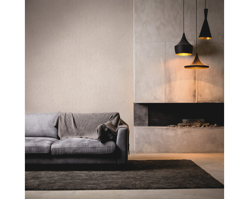 Wohnzimmer mit Sofa, Teppich, Kamin und drei Pendelleuchten