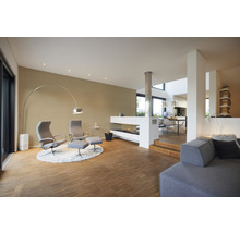 Heller Wohnraum mit Sesseln, Stehlampe und Kamin