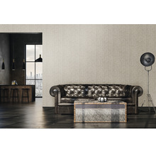Wohnzimmer mit Chesterfield-Sofa, Couchtisch und Stehlampe vor gemusterter Tapete