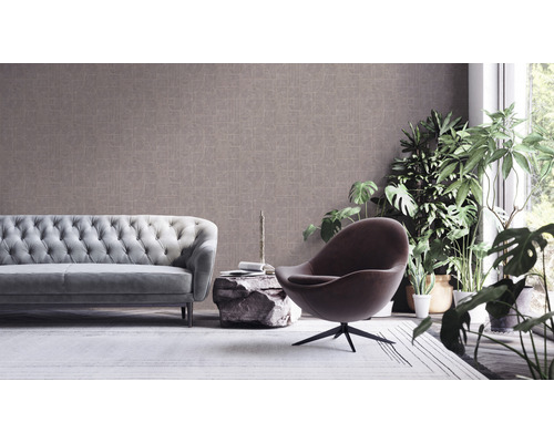 Wohnzimmer mit Sofa, Sessel und gemusterter Tapete