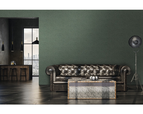 Wohnzimmer mit Ledersofa, Tisch und Stehlampe vor einer Wand mit Tapete.