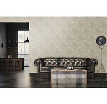 Wohnzimmer mit gemusterter Tapete, Ledersofa, Tisch und Stehlampe