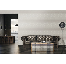 Wohnzimmer mit Ledersofa, gemusterten Tapeten und Stehlampe
