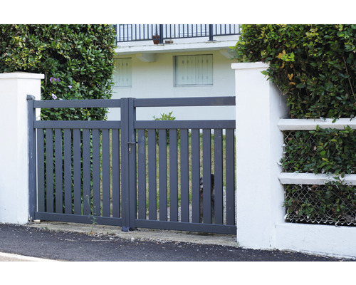 Graues Gartentor aus Metall zwischen zwei weißen Säulen