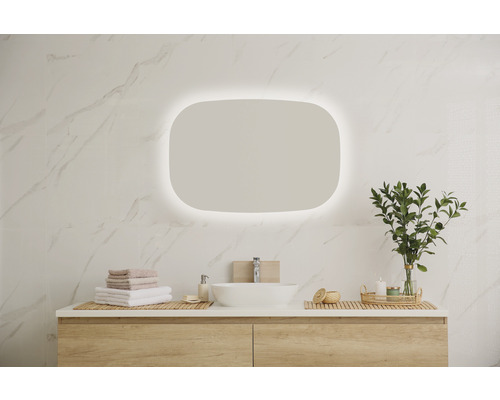 Modernes Badezimmer mit beleuchtetem Spiegel, Waschtisch und Accessoires.