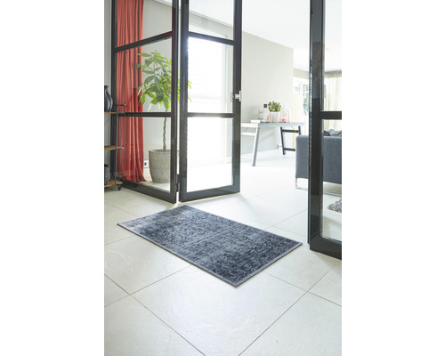 Dekorativer Teppich im Flur eines Hauses auf Fliesenboden.