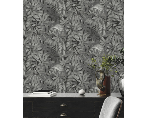 Zimmer mit botanischer Tapete mit Blättern, Kommode und Dekorationen.