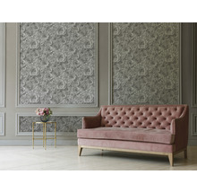 Wohnzimmer mit floraler Tapete, Sofa und Beistelltisch.