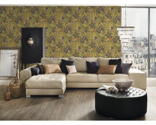 Wohnzimmer mit gemusterter Dschungeltapete, Ecksofa, Ottomane und Dekorationen für eine lebendige Atmosphäre