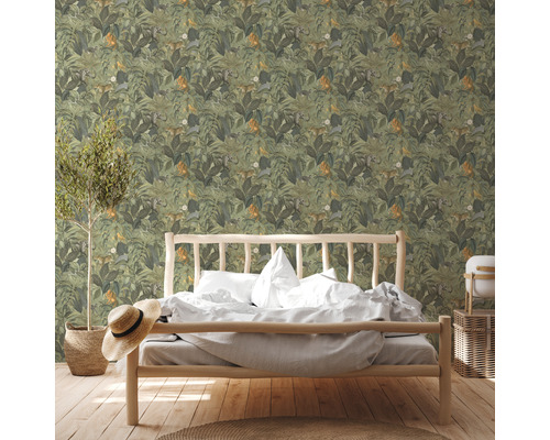 Ein Schlafzimmer mit einer Wand, die mit einer Tapete mit Dschungelmotiven und Tieren bedeckt ist.