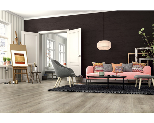 Wohnzimmer mit hellbraunem Laminatboden, rosa Sofa und Staffelei.