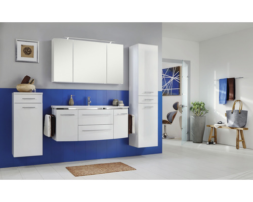 Modernes Badezimmer mit weißen Möbeln, Spiegelschrank, Waschtisch, und Hochregal vor einer blauen Wand.