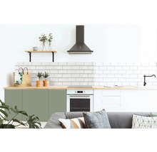 Moderne Küche mit weißen Metrofliesen, grünen und weißen Schränken, Dunstabzugshaube und Holzelementen.