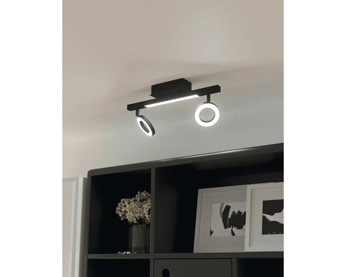 Schwarze LED Deckenleuchte mit runden und rechteckigen Leuchten über schwarzem Regal