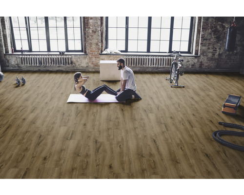 Heller Fitnessraum mit Holzboden, Sportlern und Sportgeräten