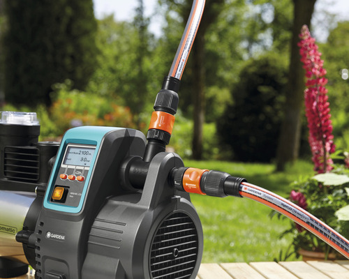 Gartenpumpe mit angeschlossenen Gartenschläuchen im Außenbereich
