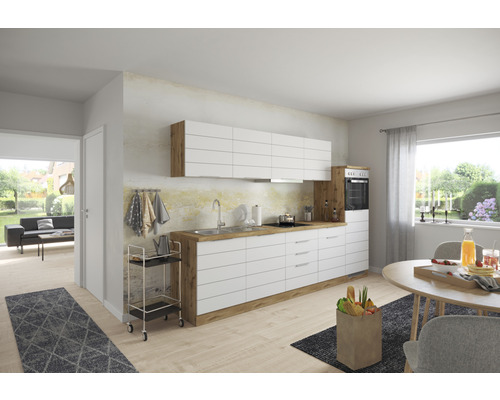 Moderne Küche mit weißen Schränken, Holzdetails und Esstisch in einem hellen Raum.