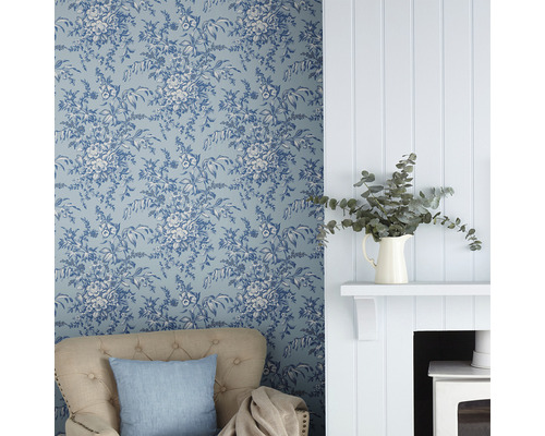 Wohnzimmer mit blumiger Tapete, Sessel und Kamin