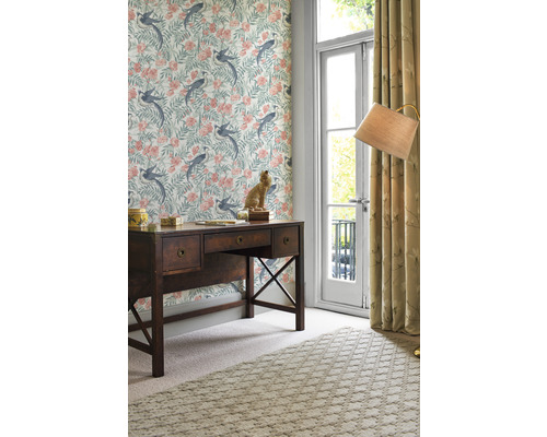 Büro mit Schreibtisch, dekorativer Tapete mit floralem Vogelmuster, Teppich und Vorhängen