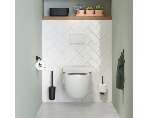 Modernes Badezimmer mit hängendem WC, Toilettenpapierhalter, Toilettenbürste und Handtuchhaken