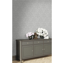 Wohnraum mit floral gemusterter Tapete und Sideboard