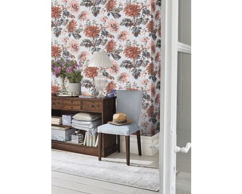 Dekorativer Raum mit geblümter Tapete, Holzkommode, Stuhl und Teppich