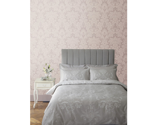 Schlafzimmer mit Bett, Nachttisch und gemusterter Tapete