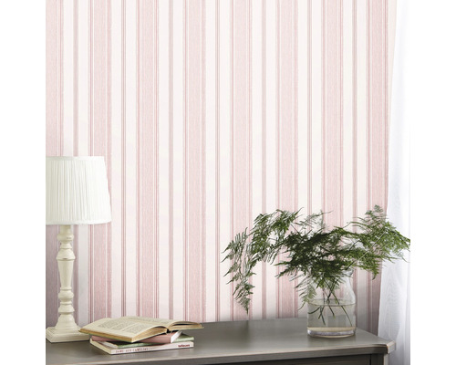 Szene mit gestreifter Tapete, Tischlampe, Pflanze im Glas und Büchern