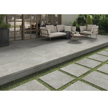 Terrasse mit Fliesenboden, Sitzbereich und Trittplatten im Garten