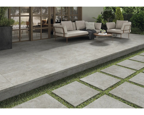 Terrasse mit Fliesenboden, Sitzbereich und Trittplatten im Garten