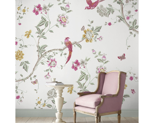 Dekorative Tapete mit Vogel-, Blüten- und Schmetterlingsmuster in einem hellen Raum mit Stuhl