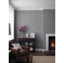 Wohnzimmer mit Sessel, Kamin und dekorativer Tapete