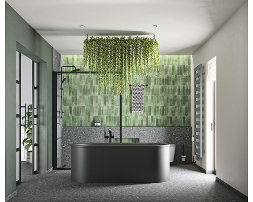 Modernes Badezimmer mit schwarzer Badewanne, grünen Fliesen und hängenden Pflanzen für eine helle und organisierte Atmosphäre.