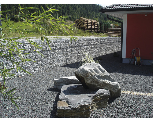 Gestaltung eines Gartens mit Steinen, Gabionenwand und Holzlager