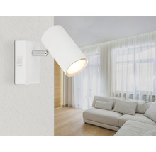 Weiße Wandleuchte mit Lichtkegel in einem Wohnzimmer.