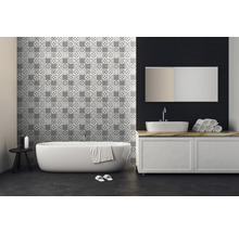 Badezimmer mit Badewanne, Waschbecken und Wandfliesen mit Muster