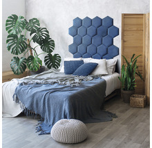 Schlafzimmer mit Bett, sechseckigem Kopfteil, Pflanzen und hölzernem Raumteiler