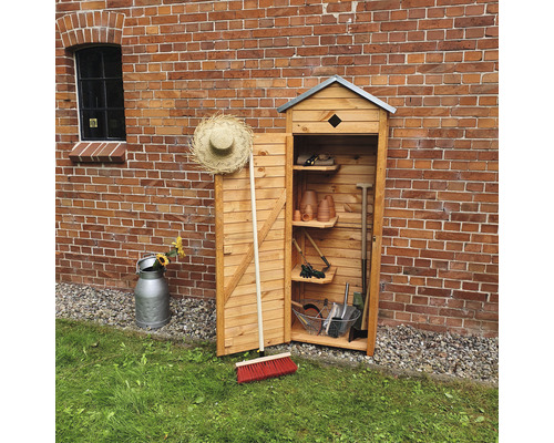 Holz Gartenschrank mit Regalen und verschiedenen Gartengeräten vor einer Ziegelmauer