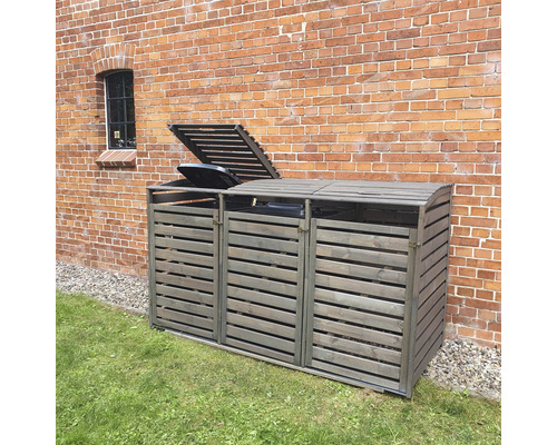 Mülltonnenbox aus Holz mit drei Fächern vor einer Ziegelwand