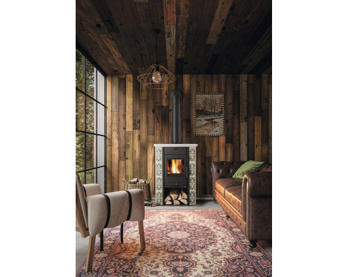 Wohnzimmer mit Holzvertäfelung, Ofen, Sessel und Sofa.