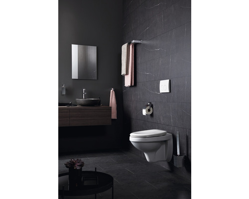 Modernes Badezimmer mit Wand-WC, Waschtisch, Spiegel und Handtüchern an einer Stange.