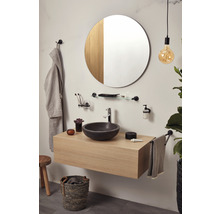 Badezimmer mit Waschtisch, rundem Spiegel, Handtuchhalter und Accessoires