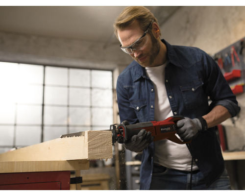 Mann sägt Holz mit einer Einhell Säbelsäge in einer Werkstatt