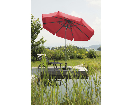 Roter Sonnenschirm neben einem Liegestuhl im Garten