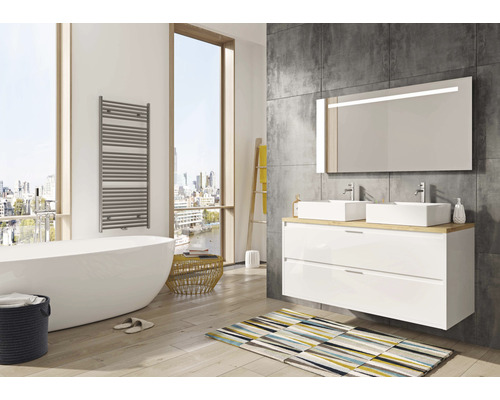 Modernes Badezimmer mit Badewanne, Waschtisch, Spiegel und Handtuchwärmer.