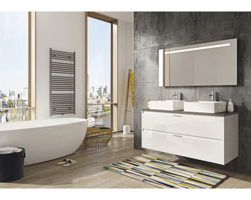 Helles Badezimmer mit Badewanne, Waschtisch mit zwei Waschbecken und beheiztem Handtuchhalter