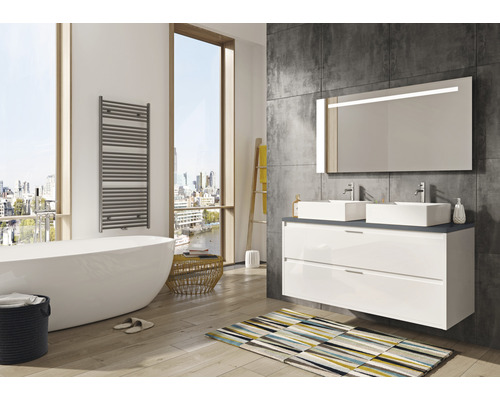 Modernes Badezimmer mit Badewanne, Waschtisch mit zwei Waschbecken, beleuchtetem Spiegel und Handtuchwärmer