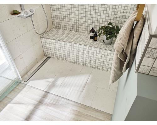 Badezimmer mit Dusche, Sitzbank, Handtuch und Zimmerpflanze