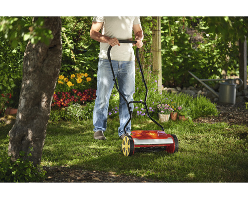 Ein Mann benutzt einen Spindelmäher im Garten
