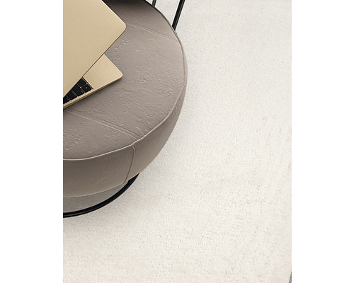 Hochflor Teppich neben einem Beistelltisch mit Laptop